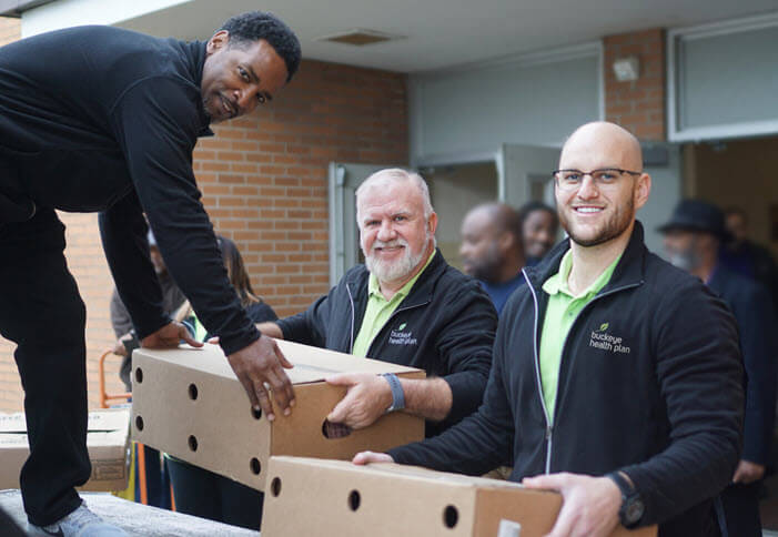 Centene employees load boxes of food on a pallet