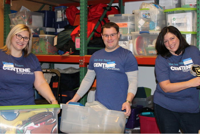 Centene employees volunteer by carrying bins of donated items