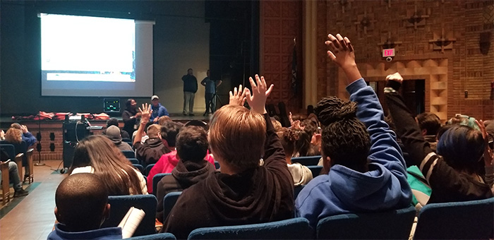 kids raise hands during social isolation presentation